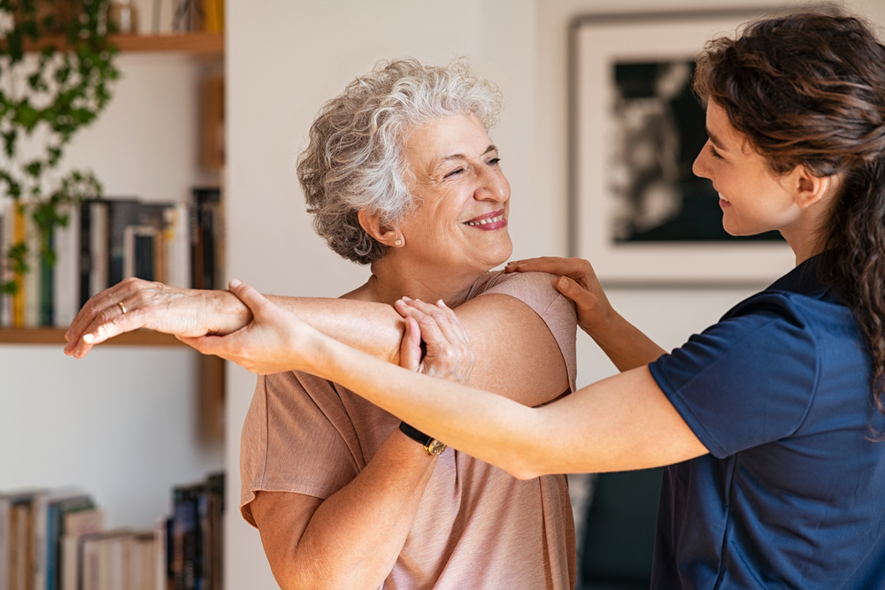 Happy,Senior,Woman,Doing,Exercise,At,Home,With,Physiotherapist.,Old